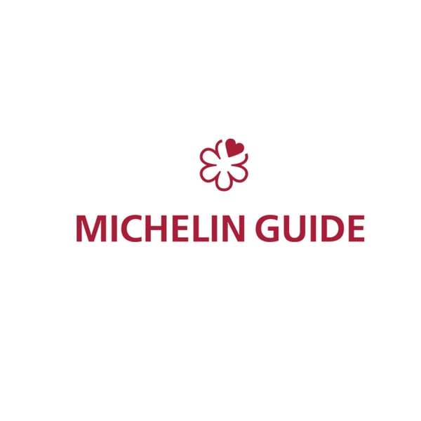 Red Michelin Guide logo with a flower-like symbol above the text on a white background.