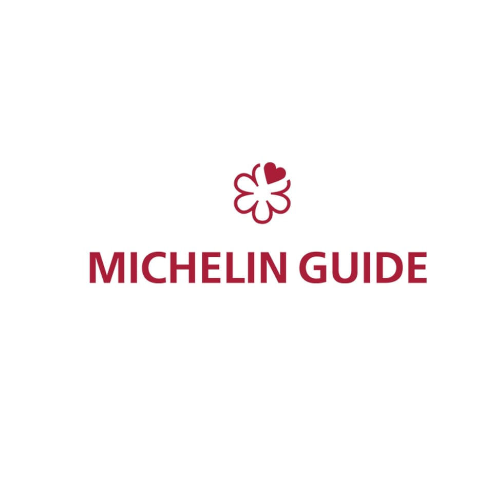 Red Michelin Guide logo with a flower-like symbol above the text on a white background.