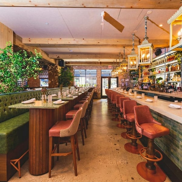 A long, narrow restaurant interior with a bar on the right and booth seating on the left.
